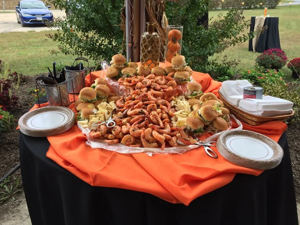 A catered spread of peel-and-eat shrimp and crab cake sliders